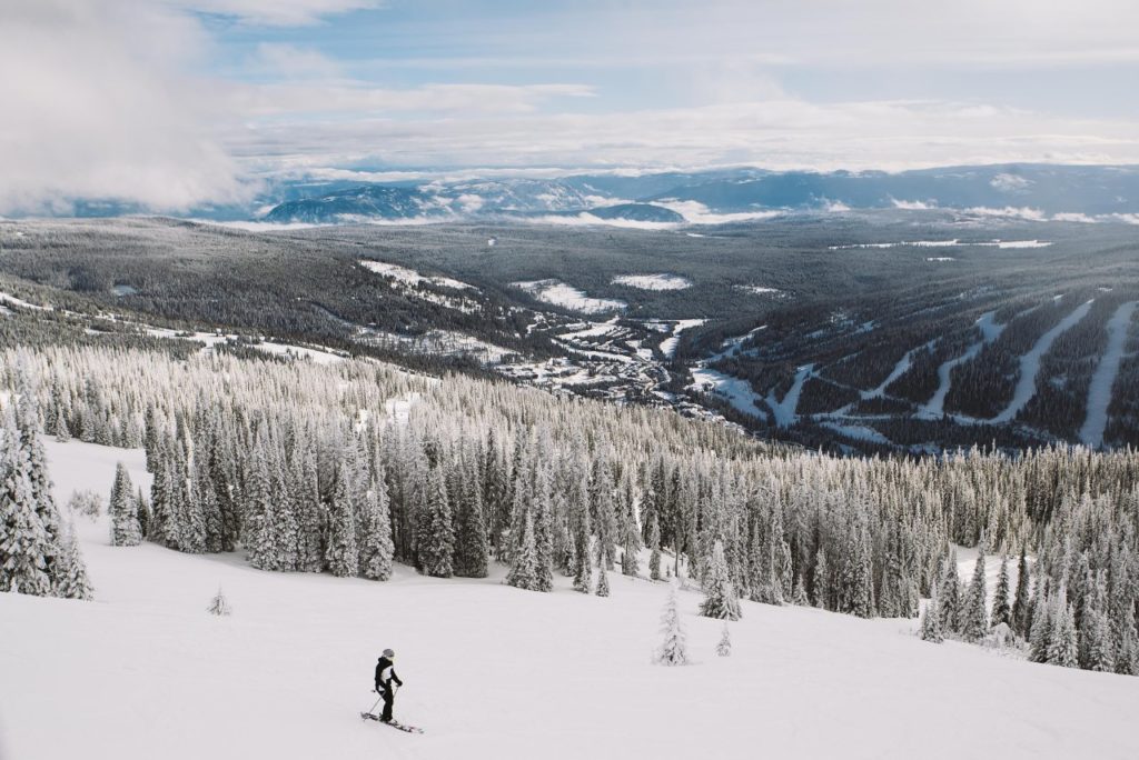 A skier stops to take in the view of Sun Peaks Resort Village.