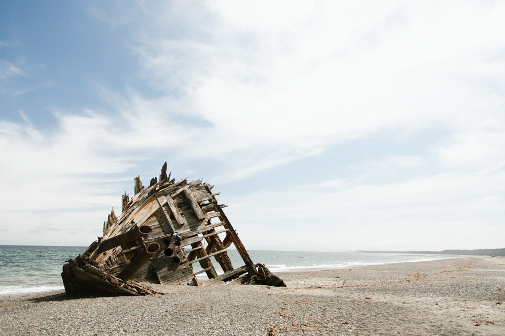 A shipwreck that has washed ashore on a beach.