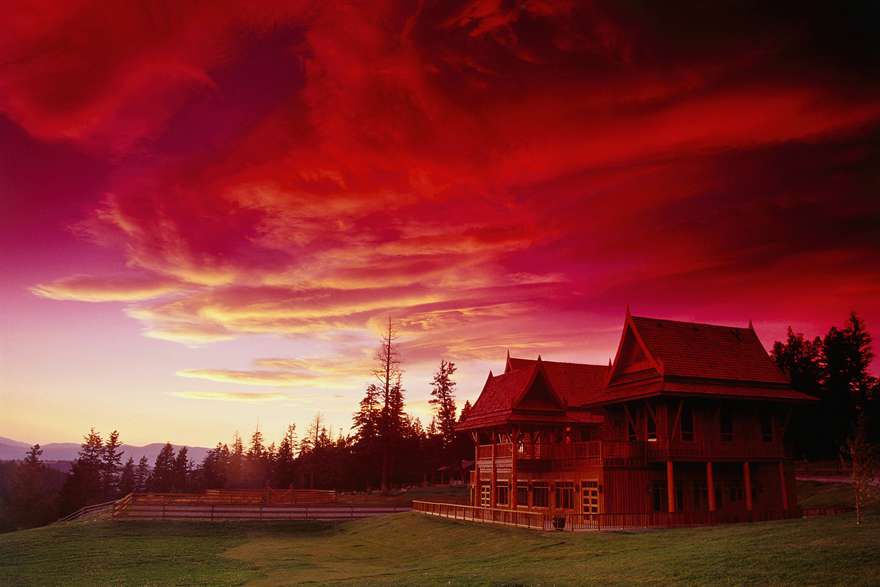 A stunning red sunset over a sprawling ranch.