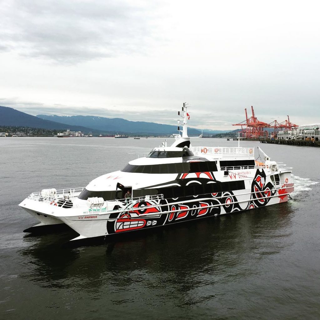 A luxury passenger ferry with red and black artwork painted down the sides.