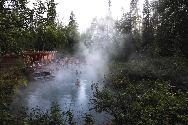 Groups of people take a dip in Liard River Hot Springs.