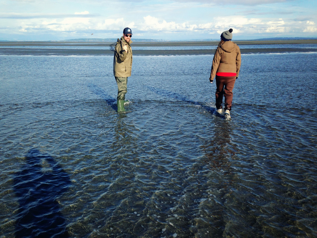 Two crab fishermen heading out in hip waders at low tide.
