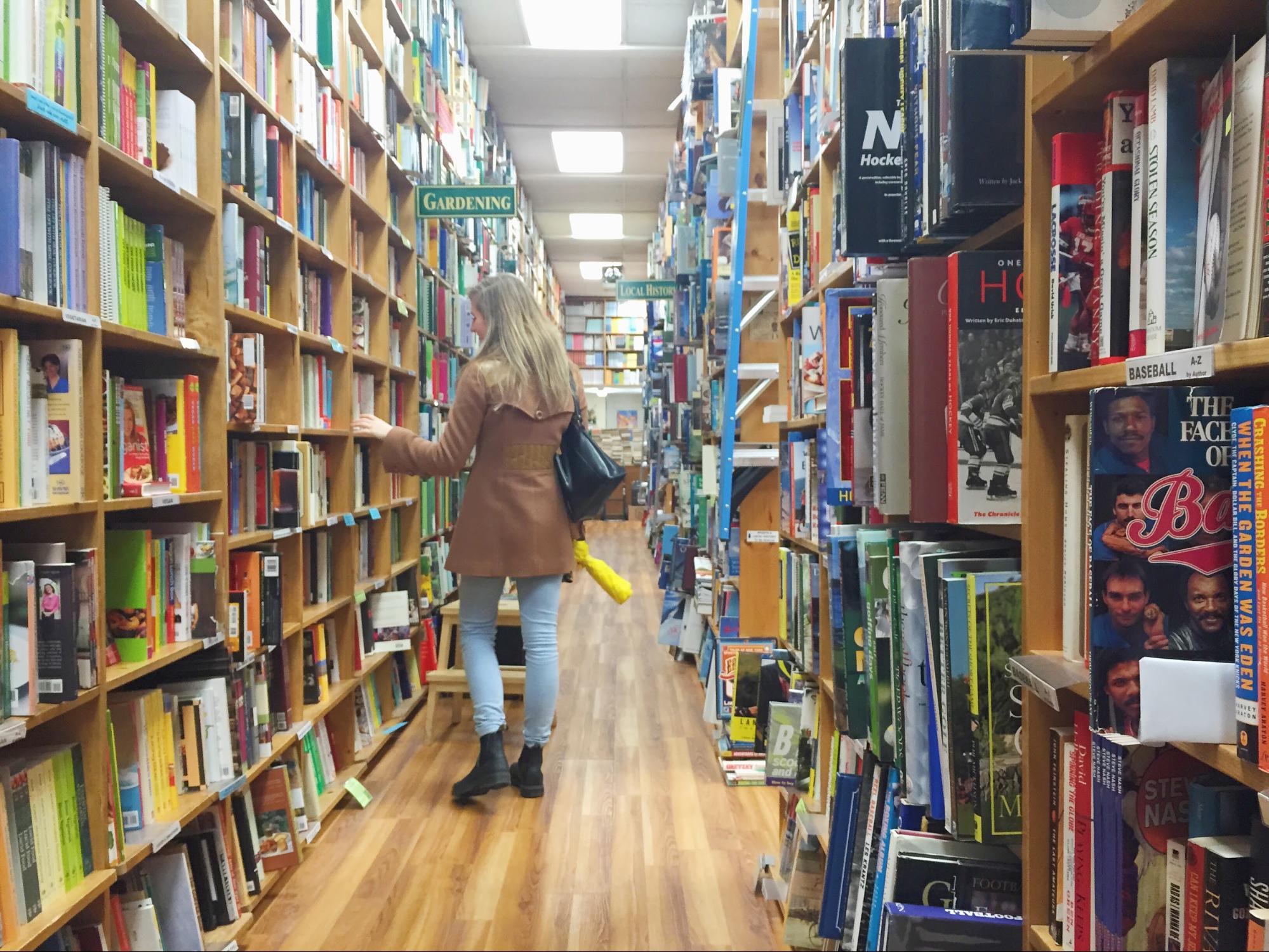 A woman explores the aisles of a used bookstore.