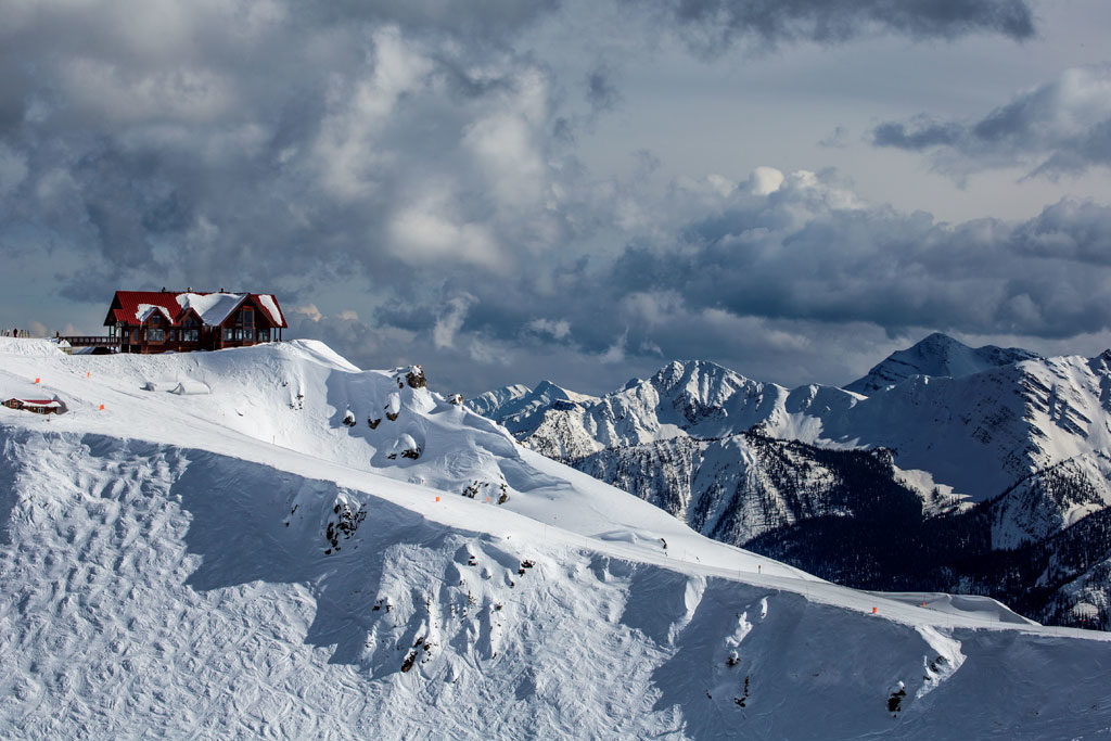 View of the lodge at peak of Kicking Horse Mountain Resort and surrounding mountains. 