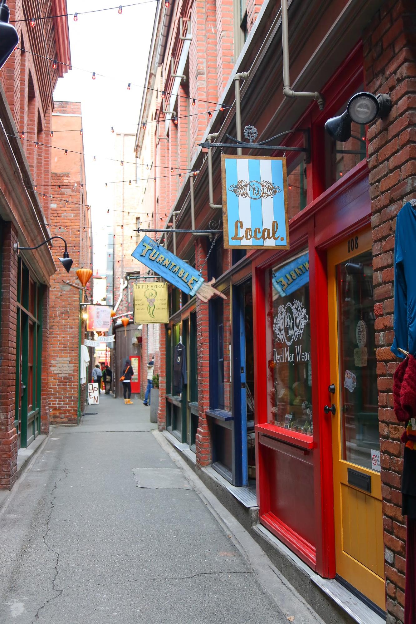 A narrow alleyway lined with colourful shops.