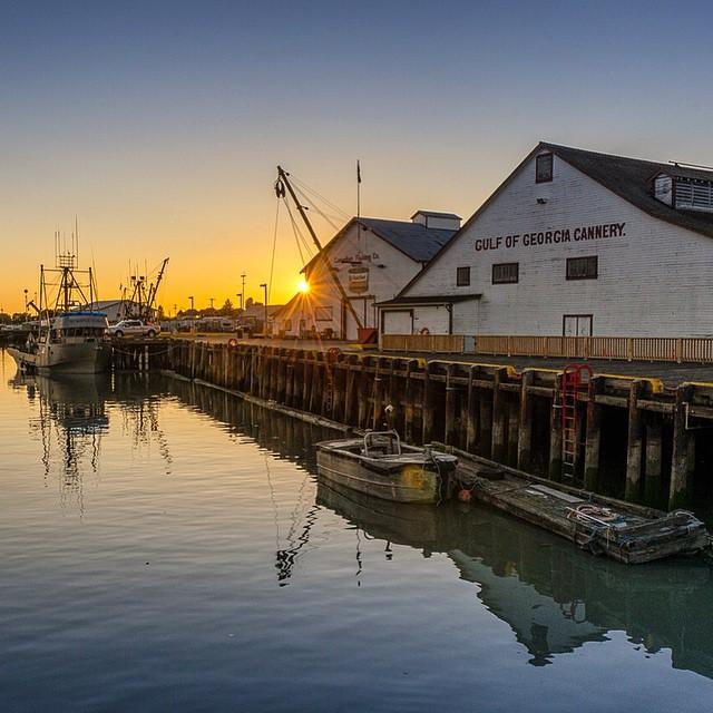 The Gulf of Georgia Cannery overlooks a quiet harbour at sunset.