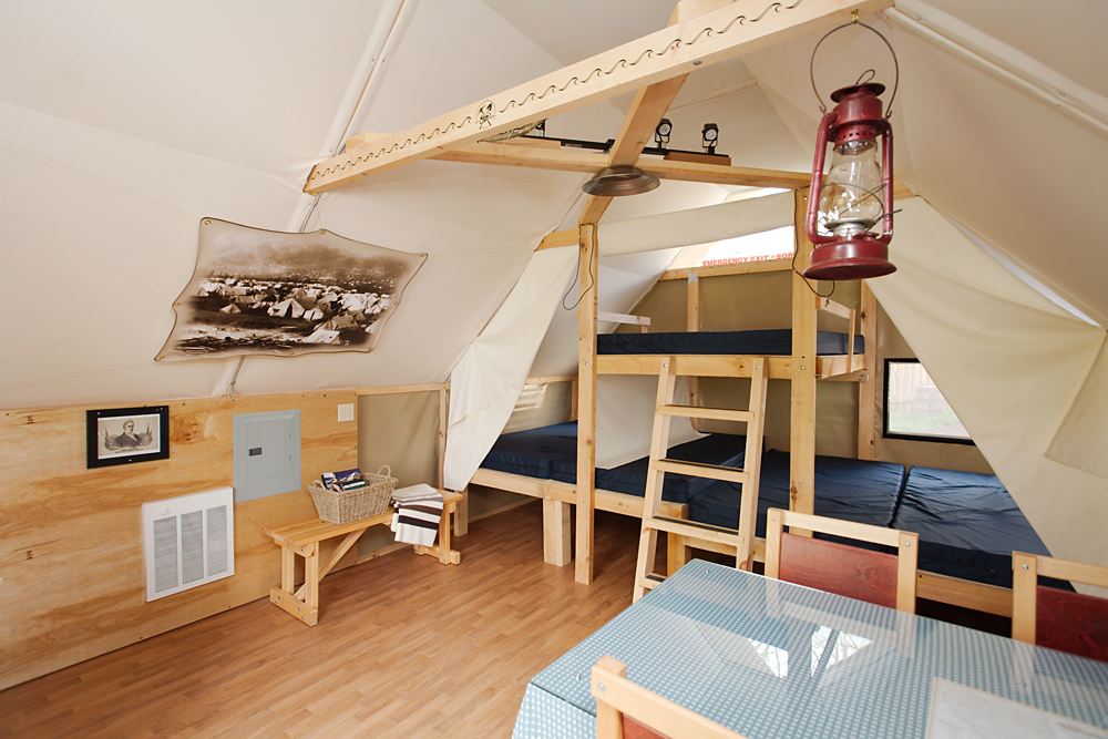The interior of an oTENTik tent with bunk beds and light touches of wood.