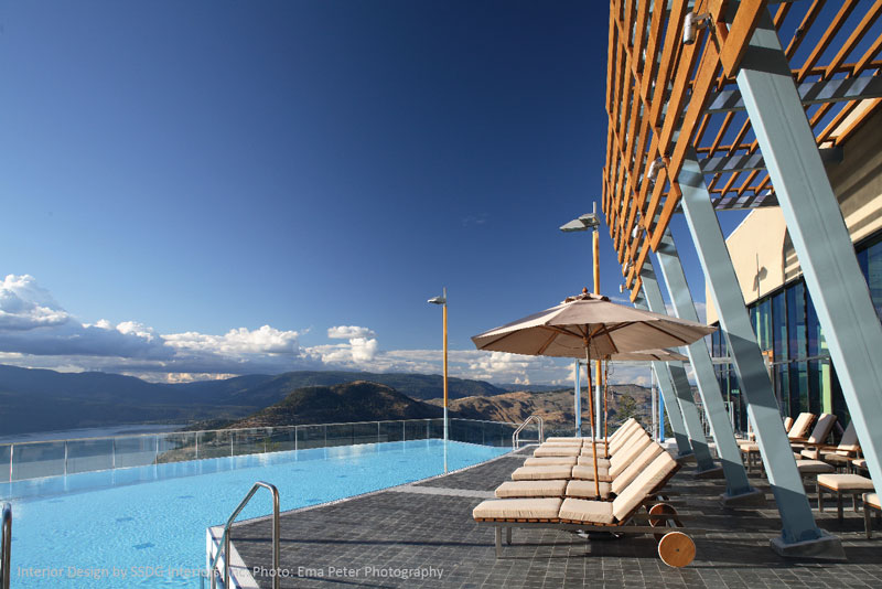 A luxurious resort pool deck with an infinity pool that overlooks a stunning landscape.