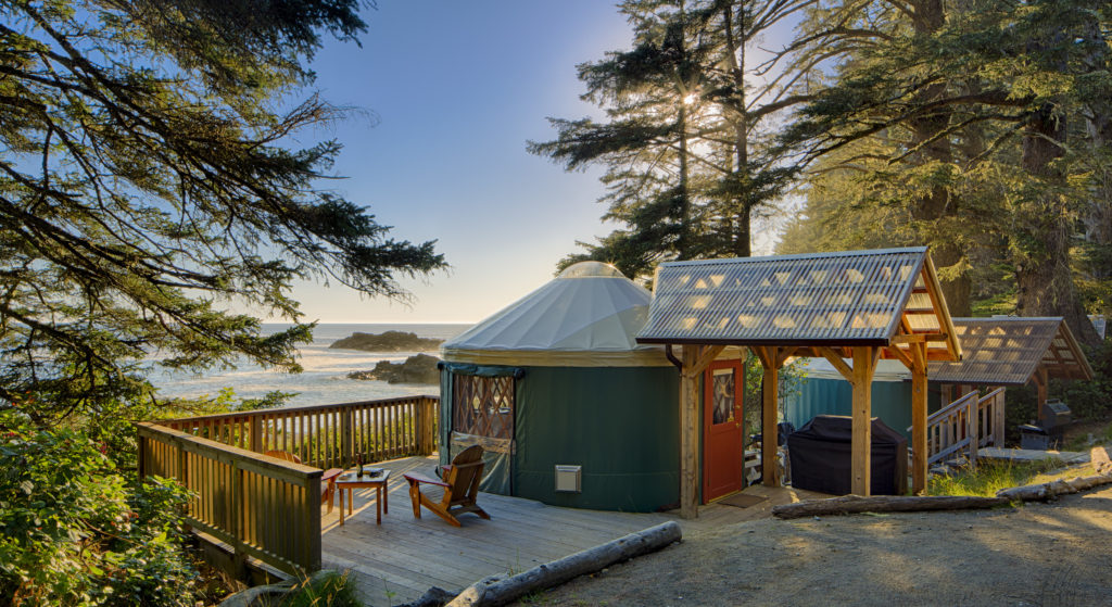 An eco-yurt looks out over the ocean at sunset.