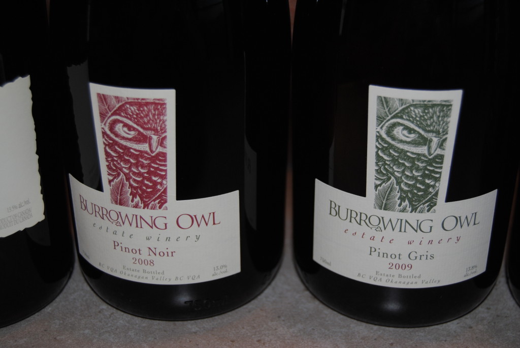 A close up view of three wine bottles with Burrowing Owl Estate Winery labels on them.