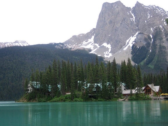 Turqouise Emerald Lake with Emerald Lake Lodge across the water and the tall mountain peaks of Yoho National Park in the background. 