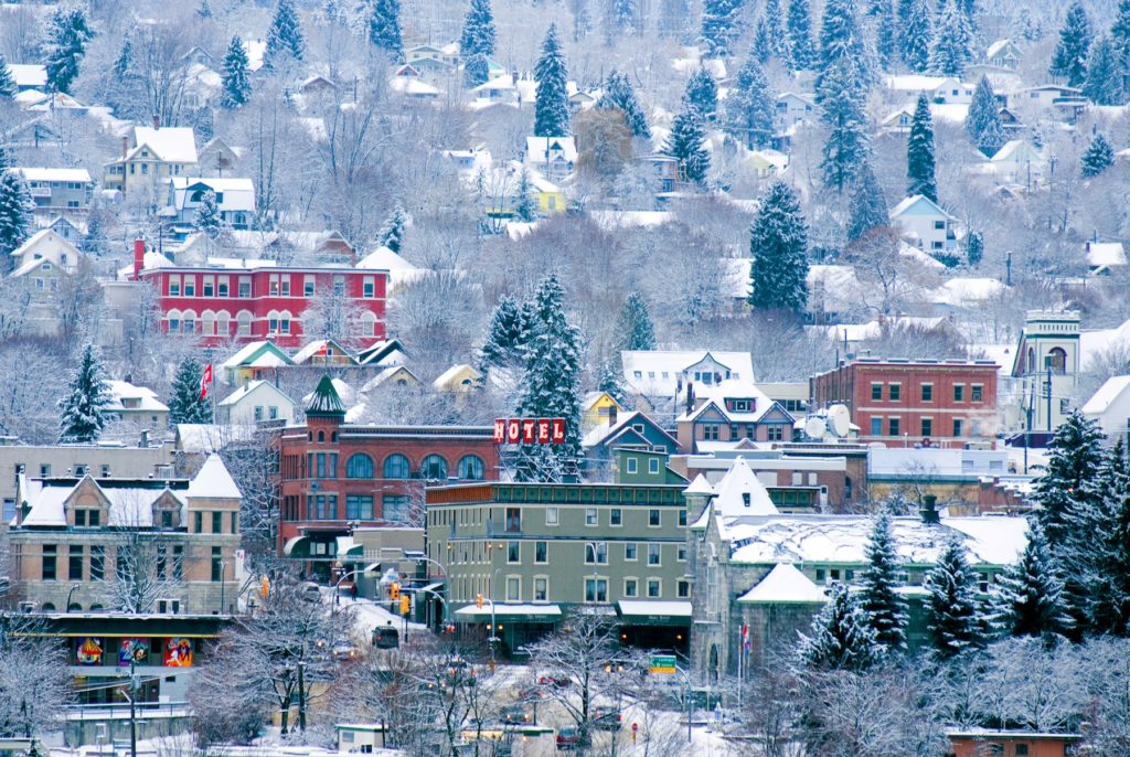 Quaint, colourful buildings are nestled in a snowy landscape.