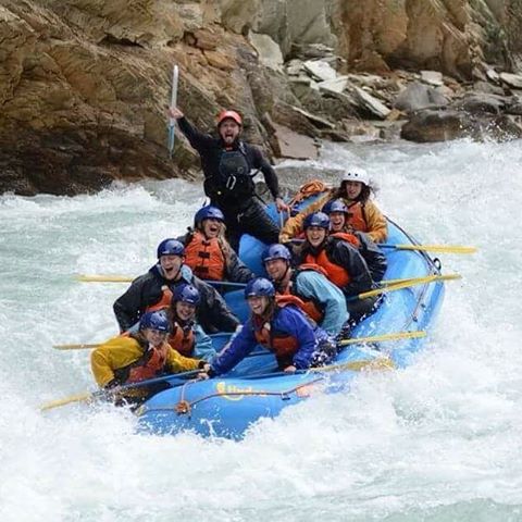 A group of men and women enjoy a white water rafting adventure. 