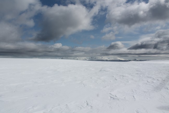 A desolate, snowy landscape under a cloudy sky.