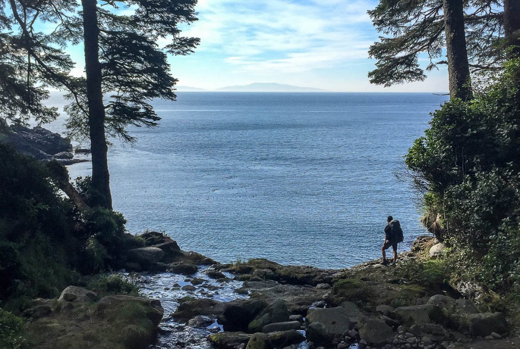 A hiker stops to take in the view of the Pacific Ocean along the Juan de Fuca Marine Trail.