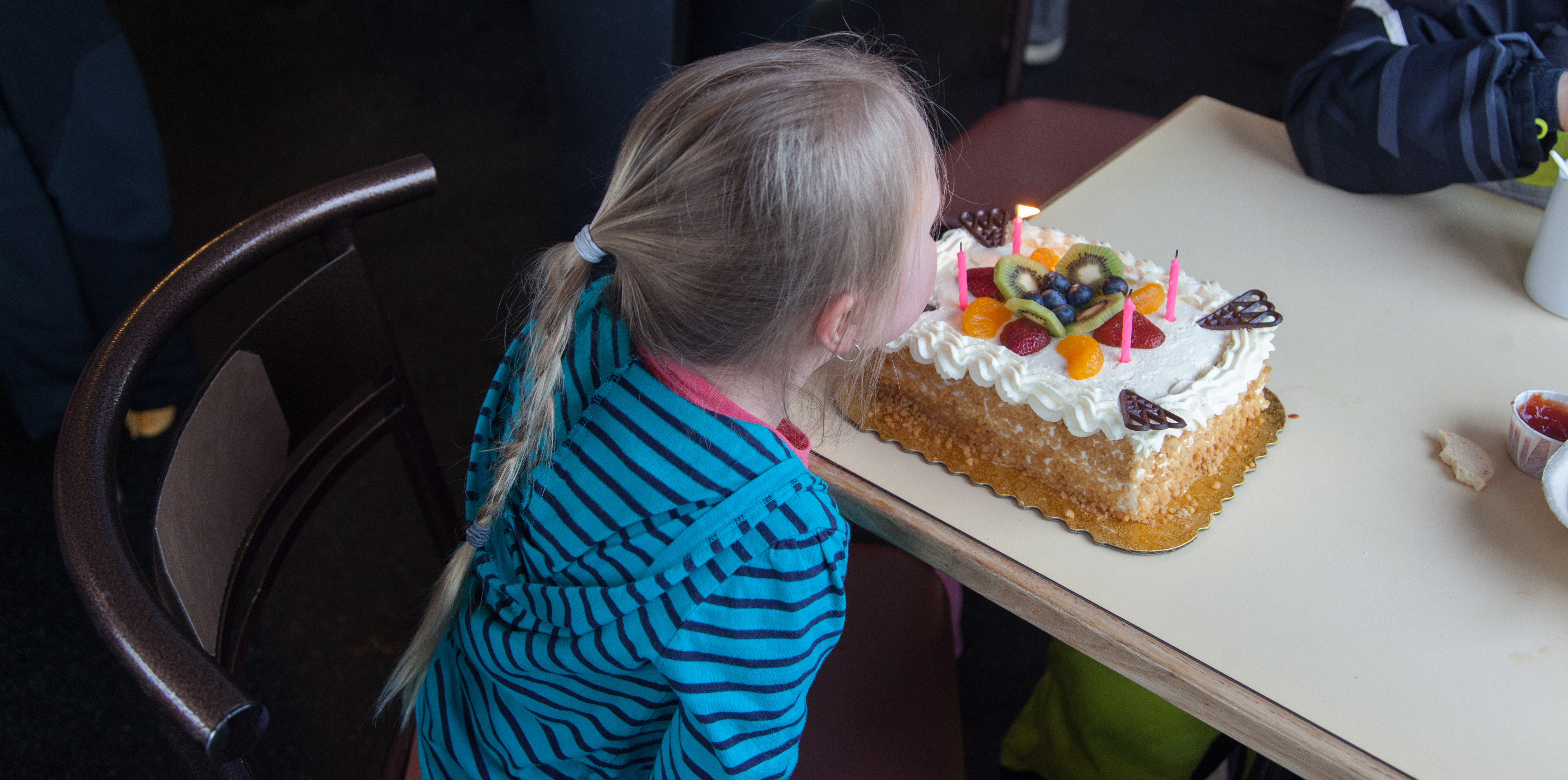 Girl blowing out birthday cake at Shames Mountain in Terrace, BC