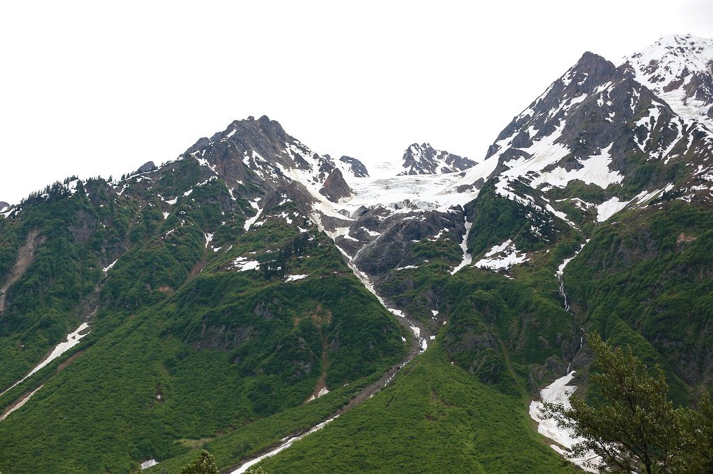 Lush green mountains with snow-covered peaks.