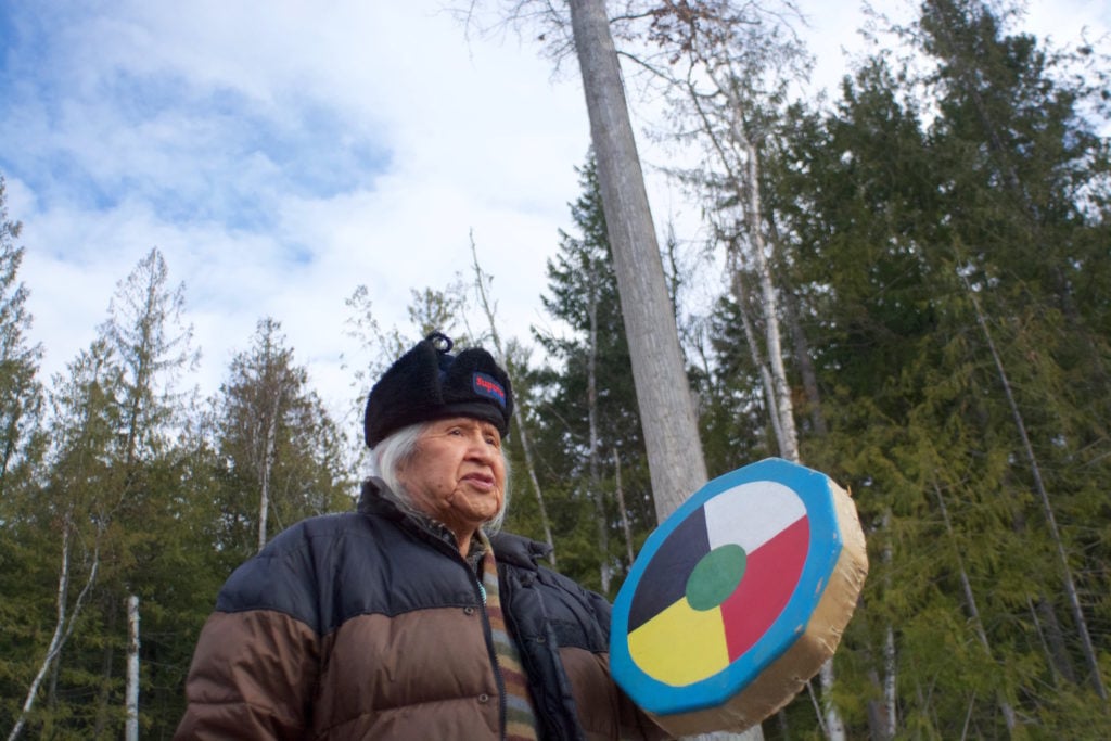 Elder Ernie Phillip drums in front of the cottonwood tree, near the town of Scotch Creek in BC's Shuswap.