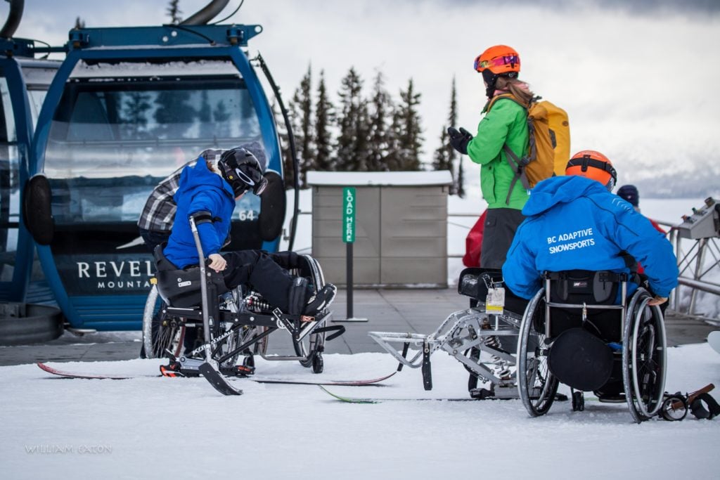 Two skiers with mobility issues in adaptive ski gear