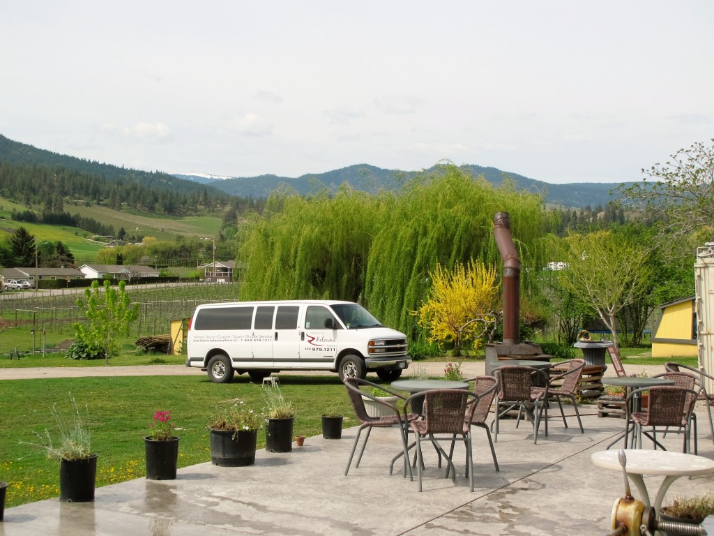 A shuttle van is parked in the driveway of a winery.