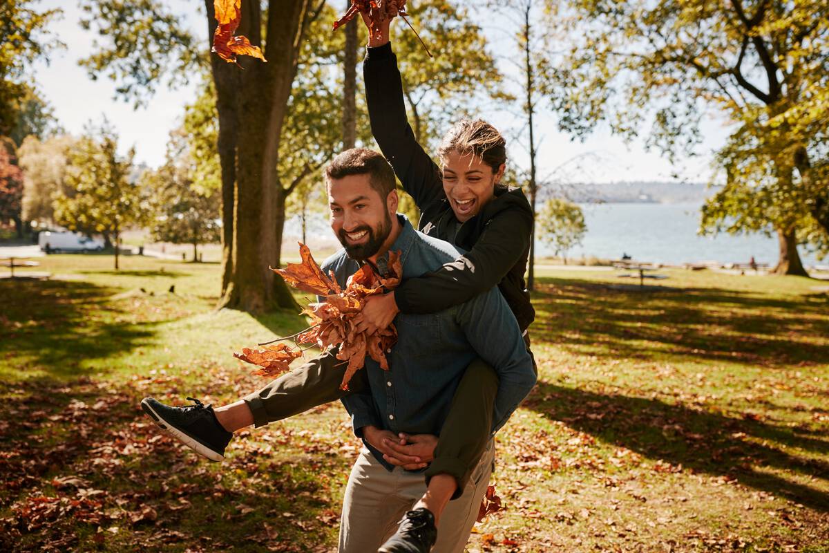 Couple playing in the park with autumn leaves | Destination Vancouver/Hubert Kang