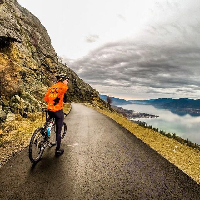 A cyclist stops to take in the view of the ocean on the Kettle Valley Trail.