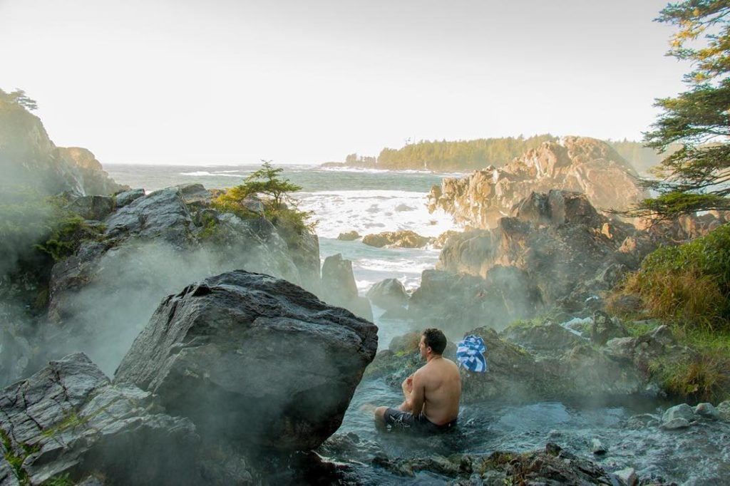 A young man sits in Clayoquot Sound’s Hot Springs Cove, overlooking the Pacific Ocean.