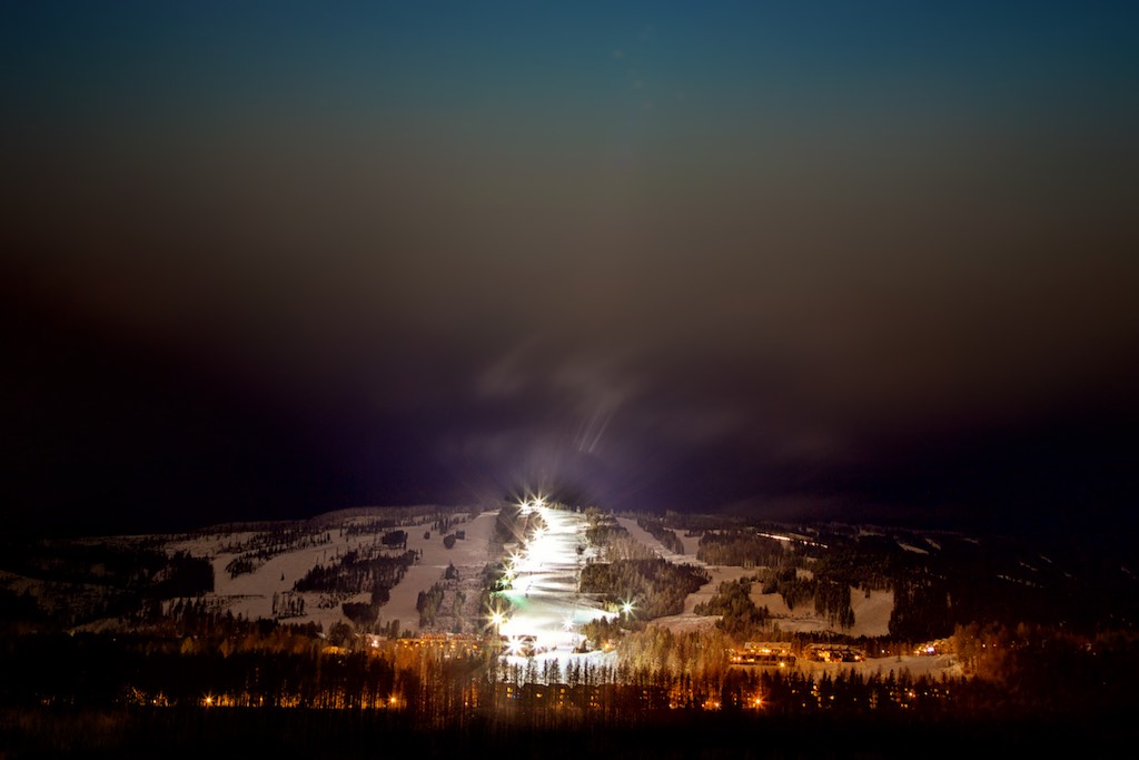 A brightly lit ski hill at night.