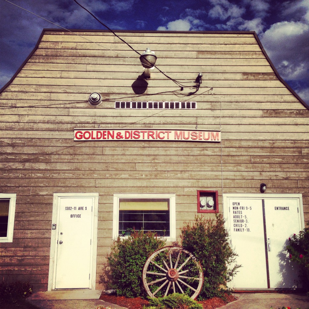 The exterior of a building with wood siding and a sign that says “Golden & District Museum”.