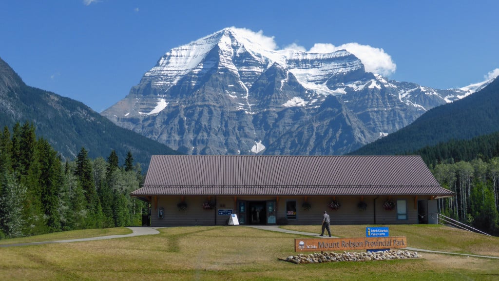 The exterior of the Mount Robson Visitor Centre with large, snow-capped mountains in the background.