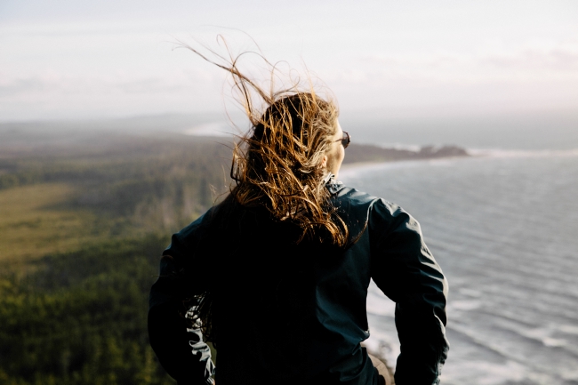 A windswept woman takes in coastal views.