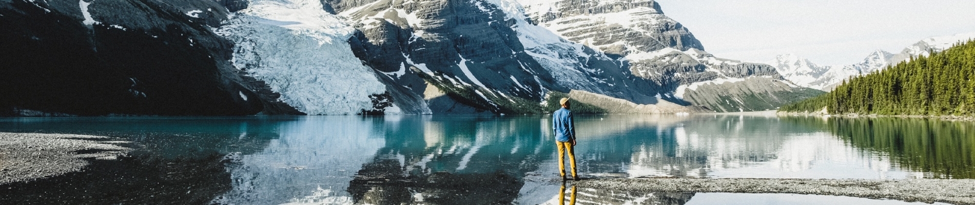 A person stands by a lake in Mount Robson Provincial Park