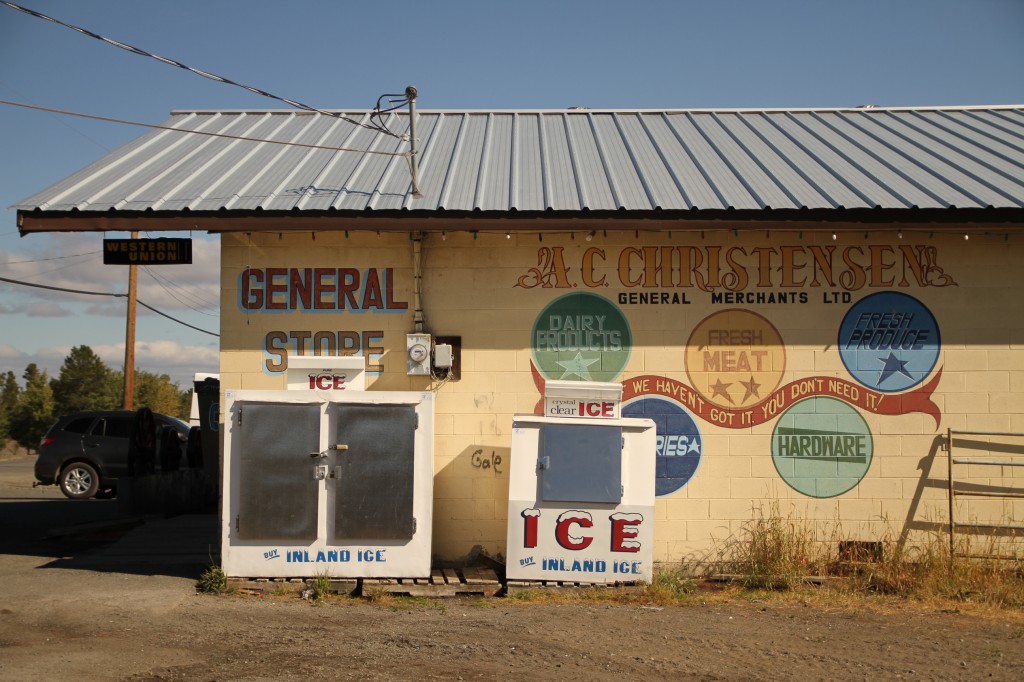 Exterior of a colourful general store with two ice machines.