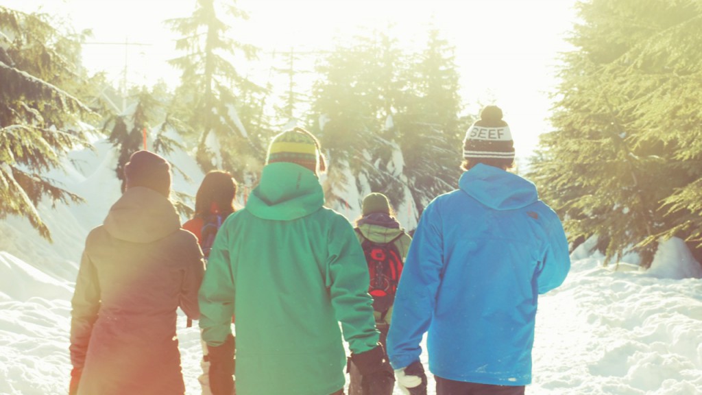 A group of people walking though a snowy forest