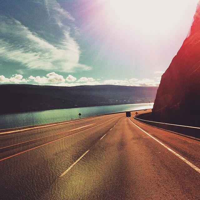 A winding coastal highway under a bright sun.