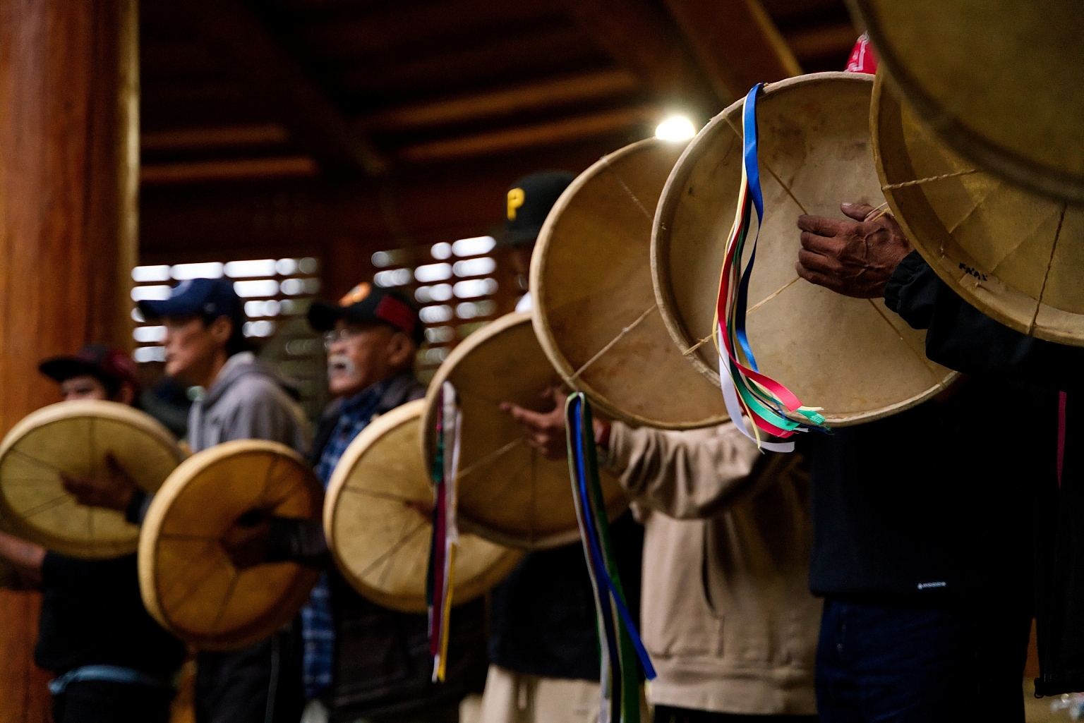 A group of Indigenous people drum at the Traditional Dene Drum Dance.