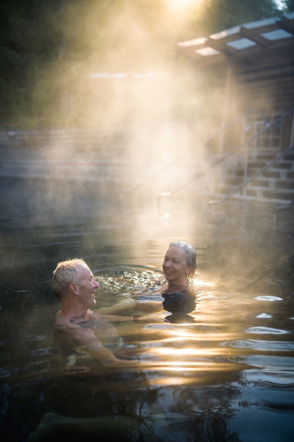 A smiling couple soaks in Liard River Hot Springs.