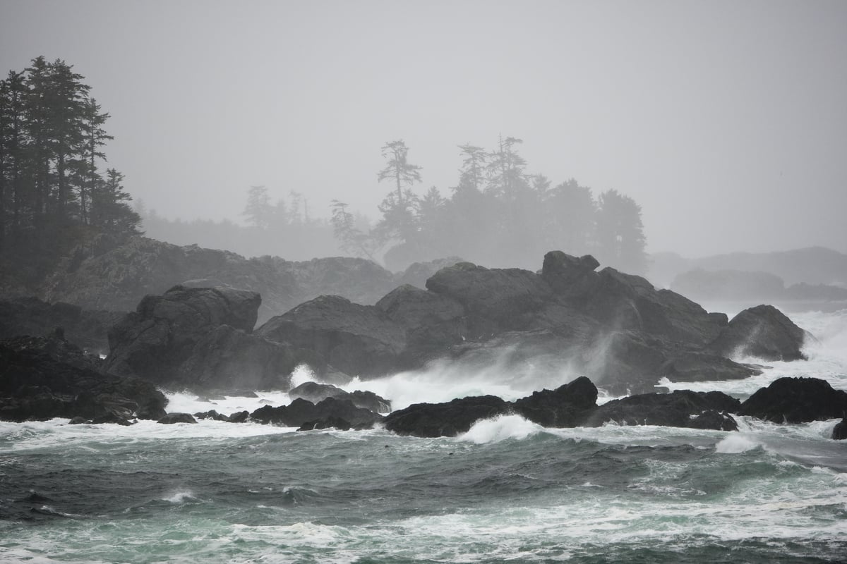Stormy waves crash onto the rocky shoreline Storm watching near Amphitrite Lighthouse along the Wild Pacific Trail