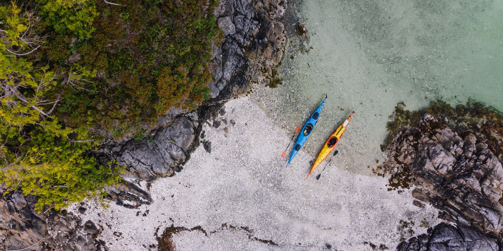 A bird-eye view of two kayaks on a beach in the Broken Islands Group.