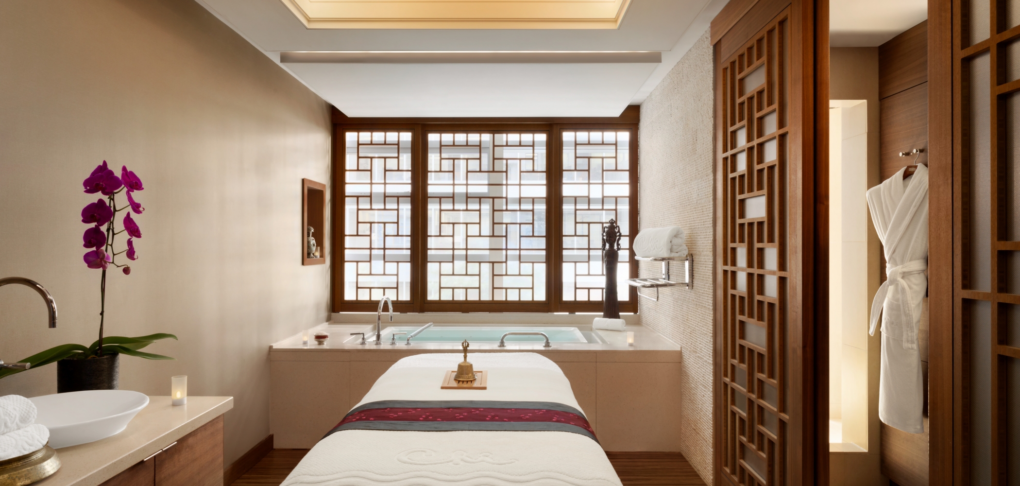 The inside of a spa room with one treatment bed and a bath at the Shangri-La Hotel, Vancouver
