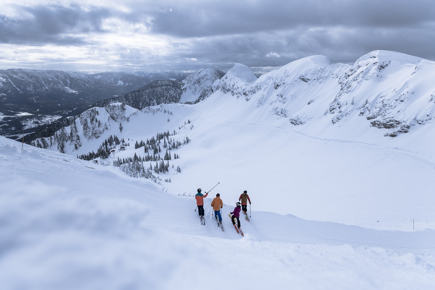 A group of skiers asses a snow covered ridge in the alpine