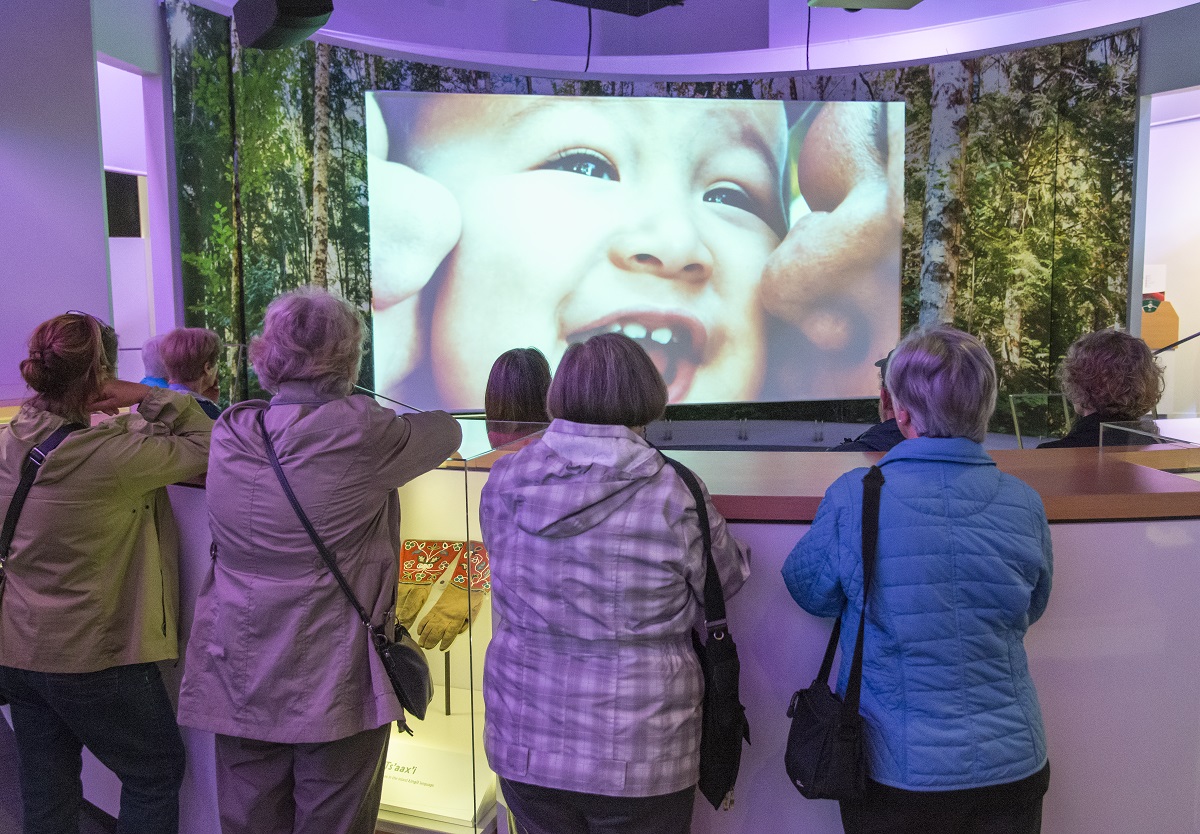 A group of seniors watch a TV screen at the Royal BC Museum's Living Languages exhibit.