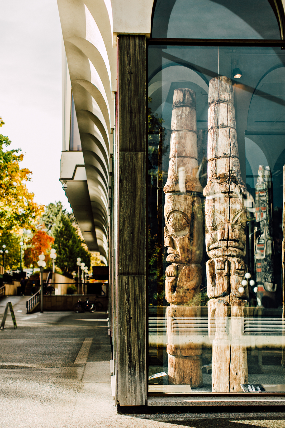 Totem poles behind glass inside the Royal BC Museum