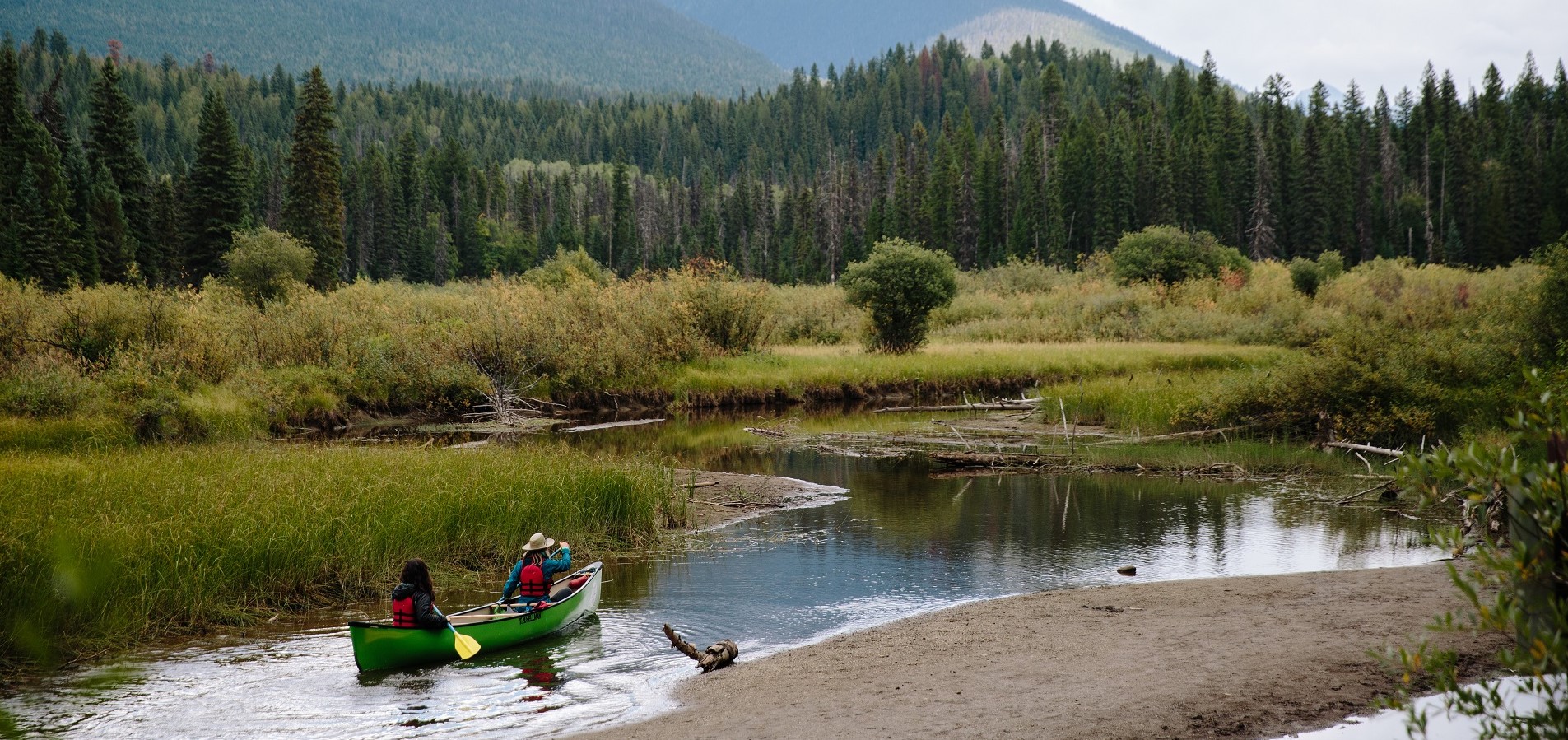 Canoers paddling through banks in Bowron Lake Provincial Park | Adam Wells