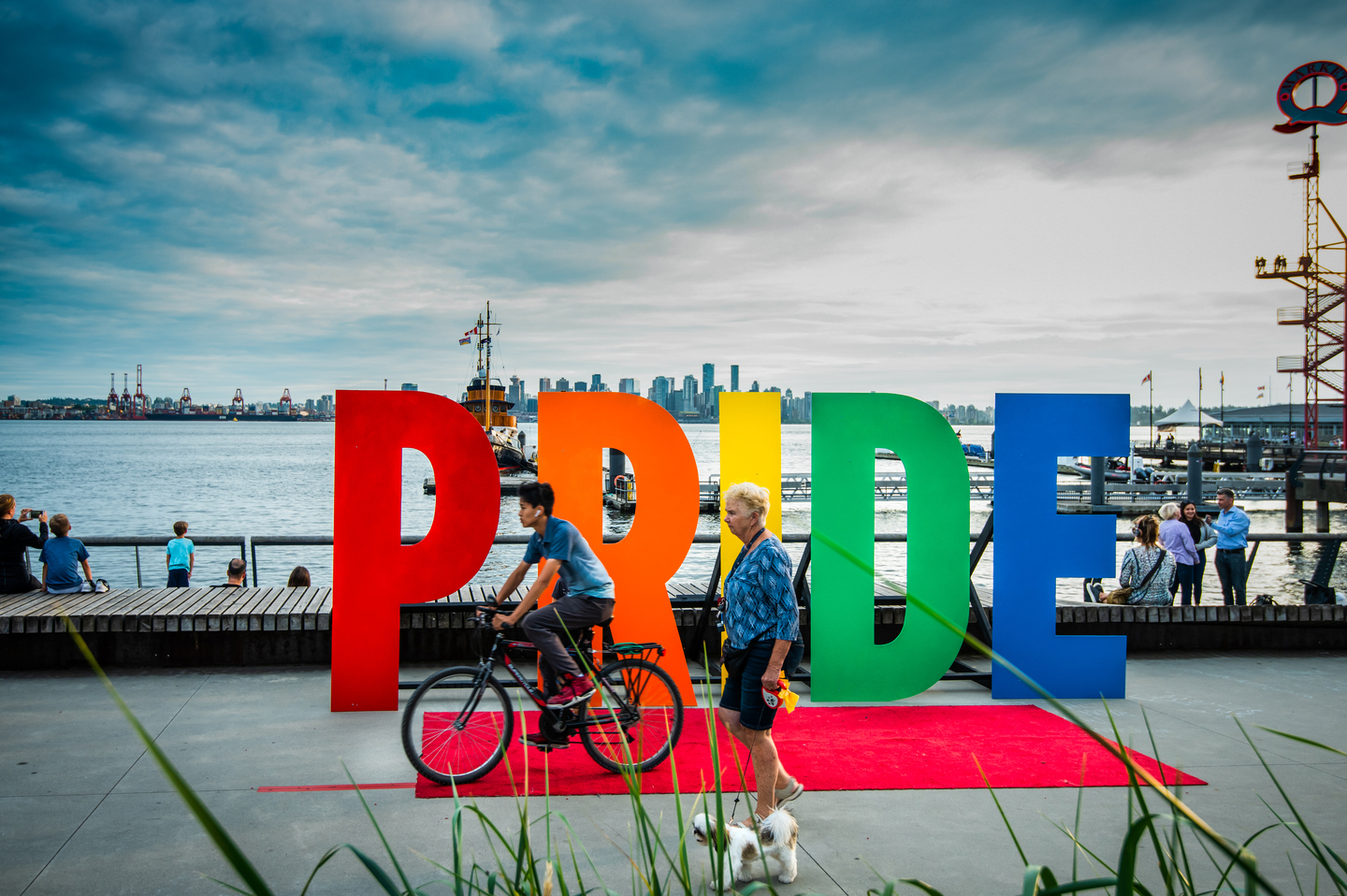 Pride sign at North Vancouver waterfront with city skyline | Tourism Vancouver / Vision Event Photography Inc.