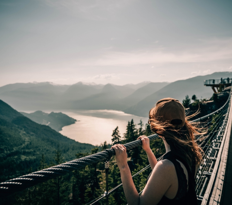 Person viewing Howe Sound from the Sky Pilot Suspension Bridge at the Sea to Sky Gondola in Squamish. | @entre2escales