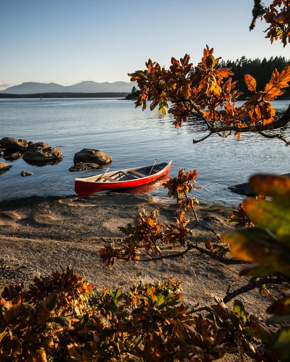 A red canoe sits on the beach on Gabriola Island