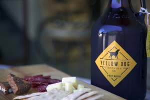 a yellow dog brewing growler with a meat and cheese board