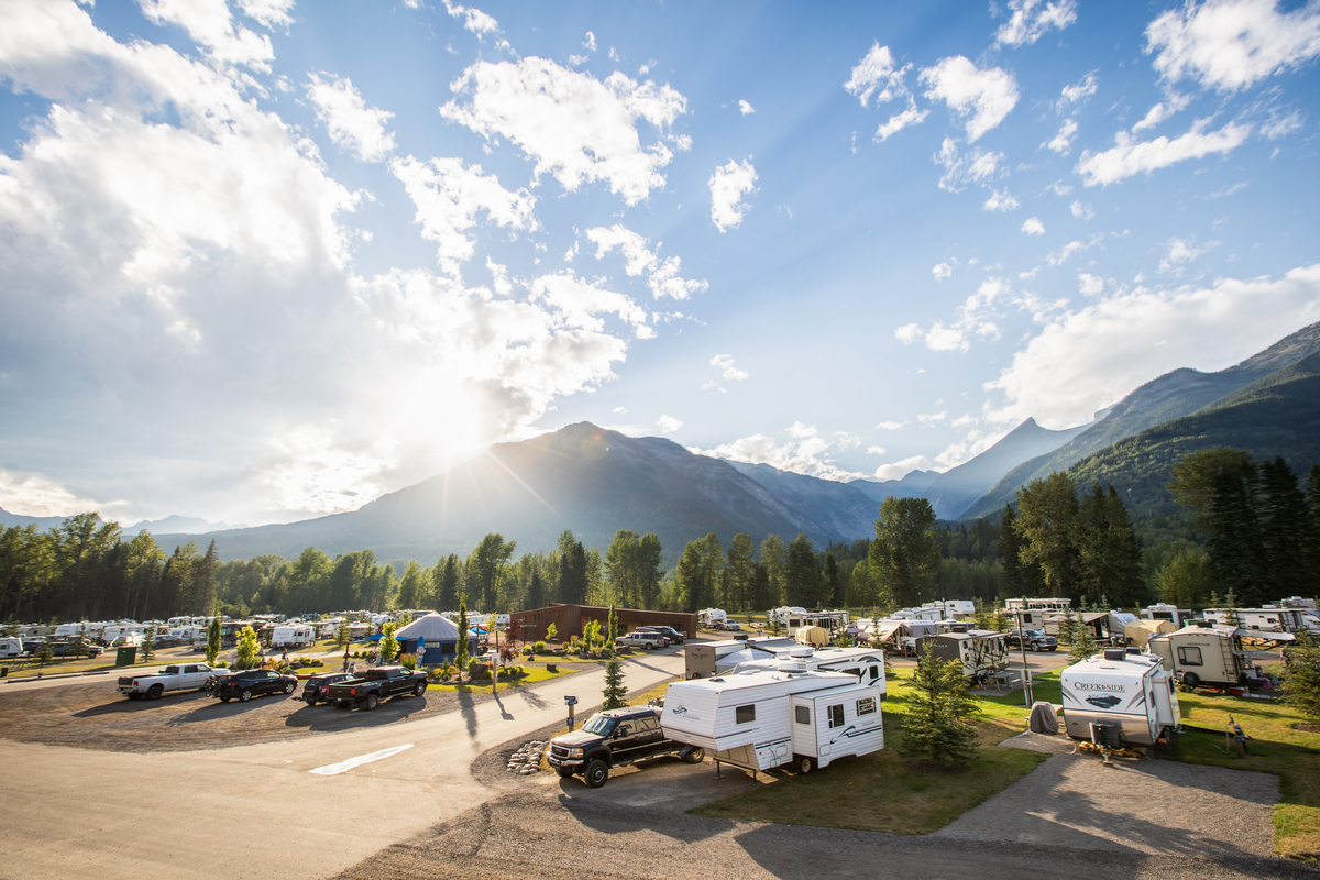An RV park is busy with RV and campers on a sunny summer day.