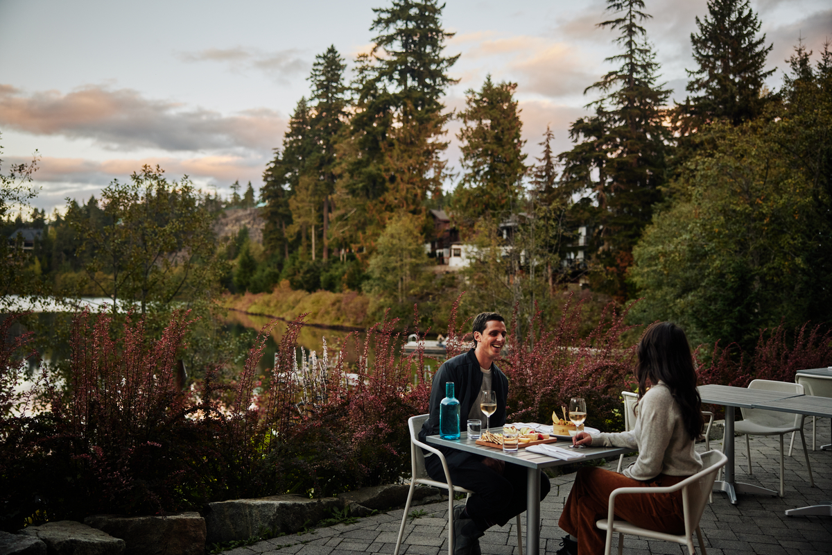 Two people dine on a patio at Nita Lake Lodge
